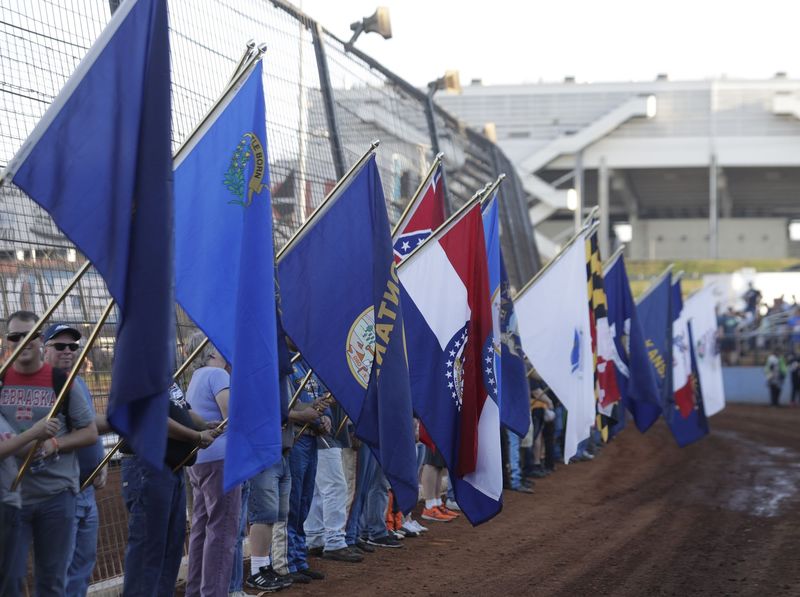 Race fans hold up flags representing their home states at last year's Textron Off Road World of Outlaws World Finals at The Dirt Track at Charlotte. Fans from 48 states and six countries are set to attend this year's event.