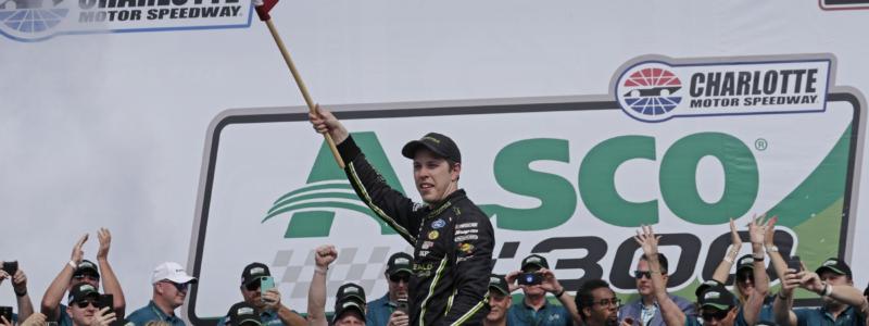 Brad Keselowski waves the American flag in victory lane at Charlotte Motor Speedway after winning Saturday's Alsco 300 NASCAR Xfinity Series race.