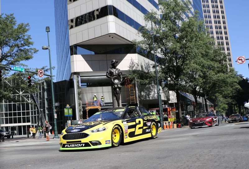 Brad Keselowski, the 2013 Bank of America 500 winner, drives a NASCAR stock car through uptown Charlotte, North Carolina, during Charlotte Motor Speedway's "Laps around Uptown" parade on Tuesday.