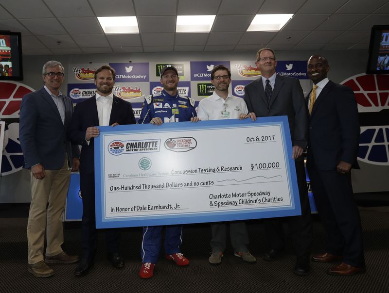 Greg Walter, Charlotte Motor Speedway executive vice president, and Speedway Motorsports, Inc. President and CEO Marcus Smith, join NASCAR driver Dale Earnhardt Jr. and representatives of Carolinas Healthcare System at a gift presentation in Earnhardt's honor on Friday at Charlotte Motor Speedway.