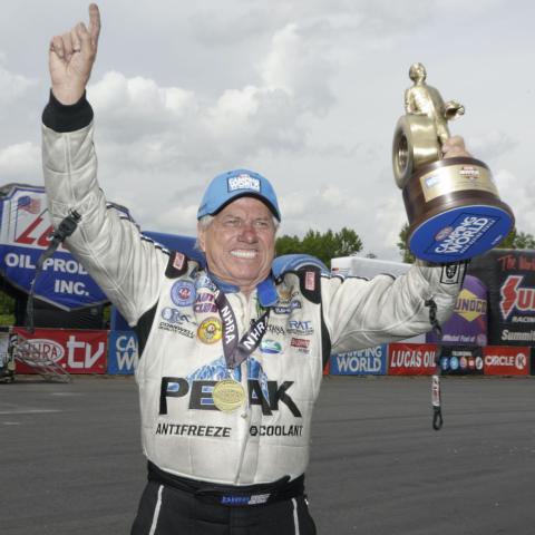 Funny Car winner John Force celebrates with his trophy after Sunday’s Circle K NHRA Four-Wide Nationals at zMAX Dragway. Force’s win was the 155th of his NHRA career. 