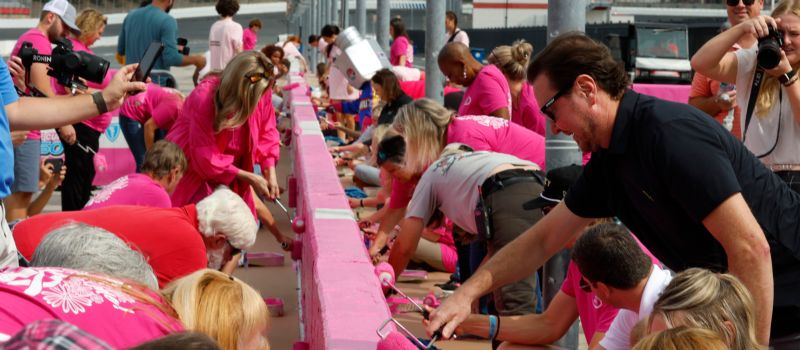 NASCAR driver Kurt Busch (top right) joined Erik Jones, Bubba Wallace and several NASCAR Xfinity Series drivers, breast cancer survivors and supporters in painting Charlotte Motor Speedway’s pit road wall pink on Tuesday during the 11th annual Paint Pit Wall Pink event ahead of next month’s NASCAR race weekend.