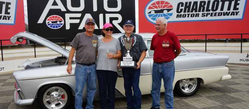 The late Walt Hollifield, a longtime car enthusiast, celebrates in Victory Lane with the winner of the Walt Hollifield Best of Show Award at the 2023 AutoFair. (CMS photo)