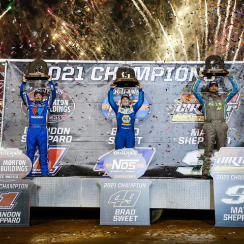 Brandon Sheppard (World of Outlaws Morton Buildings Late Models), Brad Sweet (World of Outlaws NOS Energy Drink Sprint Cars), and Matt Sheppard (Super DIRTcar Big-Block Modifieds) celebrate their championships after Saturday's NGK NTK World of Outlaws World Finals at The Dirt Track at Charlotte. 