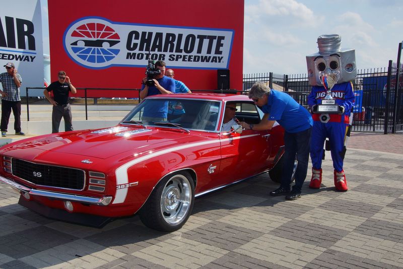 Mount Holly, North Carolina's Dan Herzberg chats with NASCAR on FOX personality Mike Joy after Herzberg's 1969 Chevrolet Camaro won Best of Show honors in Sunday's Fall AutoFair at Charlotte Motor Speedway. 
