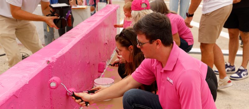 Erik Jones paints pit wall during the 12th annual Paint Pit Wall Pink event in conjunction with Blue Cross NC, sponsor of the Oct. 12 Drive for the Cure 250 at Charlotte Motor Speedway.