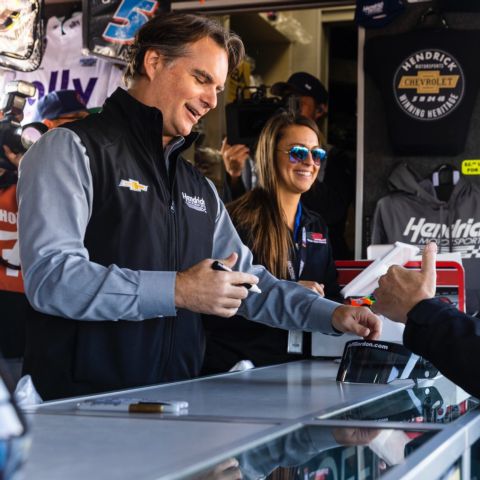 NASCAR Hall of Famer Jeff Gordon, left, signs autographs prior to Sunday's Bank of America ROVAL™ 400.