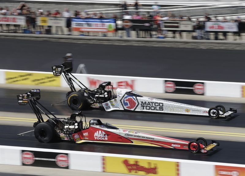 Top Fuel driver Doug Kalitta, bottom, battles Antron Brown in  Saturday's qualifying for the NHRA Carolina Nationals. Kalitta earned the No. 1 seed for Sunday's eliminations.