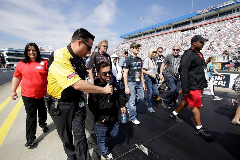 ThorSport Racing driver Rico Abreu (middle) chats as he takes part in Sunday's pre-race track walk before eliminations for the NHRA 4-Wide Nationals presented by Lowes Foods at zMAX Dragway.