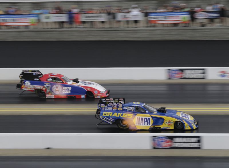 Ron Capps leads Robert Hight across the line during Sunday's Funny Car eliminations in the NHRA Four-Wide Nationals at zMAX Dragway.
