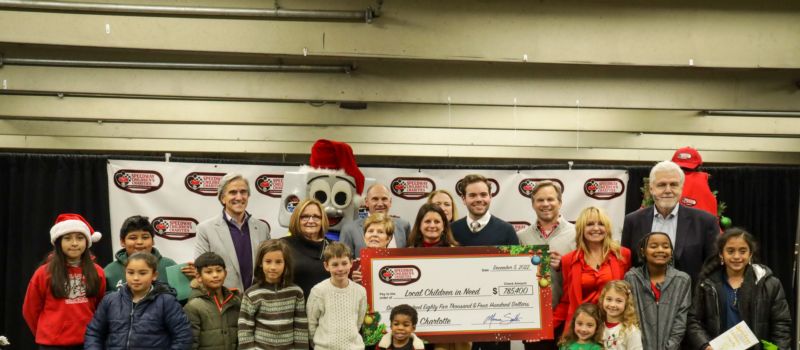 The Charlotte Chapter Board of Trustees pose for a photo with children from local nonprofits represented at the 2022 Speedway Children's Charities grant distribution event at Charlotte Motor Speedway.
