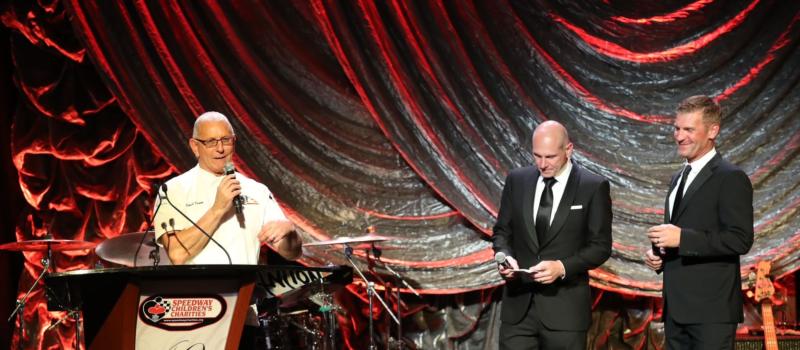 Celebrity chef Robert Irvine speaks to a crowd of nearly 400 gathered for the 40th anniversary Speedway Children's Charities Gala presented by Sonic Automotive and EchoPark Automotive as co-emcees Adam Alexander and Clint Bowyer look on. The event raised more than $1 million for Charlotte-area children in need.