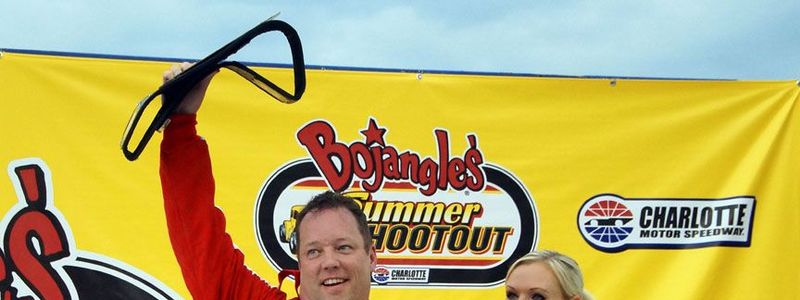 Tripp Aldredge, principal at Harris Road Middle School, celebrates in Victory Lane after winning the Bojangles' Summer Shootout School Bus Sloberknocker Tuesday night. 