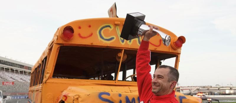 Cabarrus Virtual Academy principal Ken Simeone was all smiles after emerging victorious during a Round 2 school bus slobberknocker at the CookOut Summer Shootout on Tuesday at Charlotte Motor Speedway.