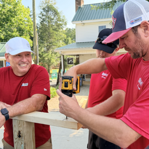 Pit crew members volunteered at Wings of Eagles Ranch, helping build a rolling communication board to support the organization's mission during the 2027 Summer of Service.