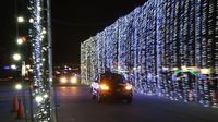 Cars drive through walls of lights created from more than 1,100 strands of lights as part of Charlotte Motor Speedway's 3.75-mile drive-through Speedway Christmas route.