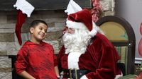 A young guest visits with Santa Claus in the Speedway Christmas village during the 2016 Speedway Children's Charities grant distribution event Wednesday at Charlotte Motor Speedway.