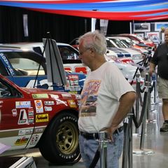 Onlookers study the street legal stock cars on display in the Showcase Pavilion during the opening day of the Pennzoil AutoFair presented by Advance Auto Parts.