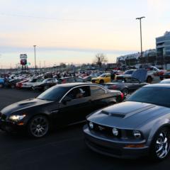 A driver backs into his parking spot among hundreds of cars on display during the inaugural Cars and Coffee Concord at Charlotte Motor Speedway.