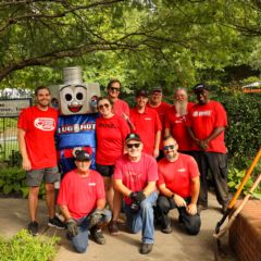 Speedway Motorsports volunteers pose for a photo with Lug Nut during the fifth annual Day of Service.