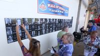 Longtime fans take photos in front Charlotte Motor Speedway's Wall of Fame following a special breakfast honoring fans who have been visiting the speedway for more than 50 years.
