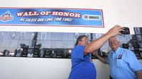 Longtime fans take photos in front Charlotte Motor Speedway's Wall of Fame following a special breakfast honoring fans who have been visiting the speedway for more than 50 years.