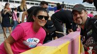 Mia Hamm and NASCAR Whelen Southern Modified driver Bobby Measmer Jr. take a break from painting the pit road wall to pose for a photo during an event to kick off Breast Cancer Awareness Month and preview the Drive for the Cure 300 NASCAR XFINITY Series race at Charlotte Motor Speedway.
