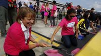 Blue Cross Blue Shield of North Carolina brand ambassador Mia Hamm (right) and senior vice president and chief human resources officer Fara Palumbo helped paint pit road wall pink to kick off Breast Cancer Awareness Month and preview the Drive for the Cure 300 NASCAR XFINITY Series race at Charlotte Motor Speedway.
