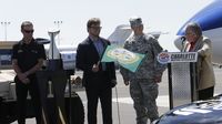 Charlotte Motor Speedway President and General Manager Marcus Smith (second from left) presents a green flag to U.S. Army Capt. Chris Neeman to officially kick off the Chase for the NASCAR Sprint Cup championship and the countdown to the Bank of America 500, during a three-city tour to preview the NASCAR Chase Across America and the Bank of America 500.