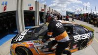 A crew member pushes the No. 41 car of Kurt Busch into the garage between practice runs during Bojangles' Pole Night at Charlotte Motor Speedway.