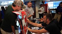 Austin Dillon signs a piece of sheet metal during the seventh annual Parade of Power at Charlotte Motor Speedway on Wednesday.