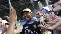 Antron Brown high-fives fans after winning the Top Fuel Wally during elimination Sunday at the NHRA Carolina Nationals at zMAX Dragway.