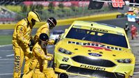 Crew members change tires on the No. 22 machine of Joey Logano during a rare Sunday Bank of America 500/Drive for the Cure 300 doubleheader at Charlotte Motor Speedway.