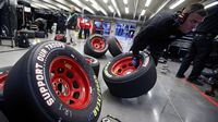 Crews shuffle tires in the garage area during Thursday's practice session at Charlotte Motor Speedway.