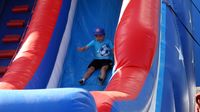 A young fan races down a slide at the pit party during the Circle K Back-to-School Monster Truck Bash at The Dirt Track at Charlotte.