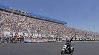 John Force salutes a huge crowd between runs during elimination Sunday at the NHRA 4-Wide Nationals presented by Lowes Foods.