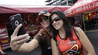 Pro Stock Motorcycle rider Angelle Sampey poses for a photo with a fan during Saturday's qualifying action at the NHRA Carolina Nationals at zMAX Dragway.