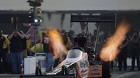 Header flames shoot out above the 10,000-horsepower engine of Clay Millican's Top Fuel dragster during the opening day of the NHRA Carolina Nationals at zMAX Dragway.