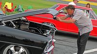 A car enthusiast snaps a photo of some American muscle under the hood on All-American Sunday at the 22nd annual Goodguys Southeastern Nationals at Charlotte Motor Speedway.