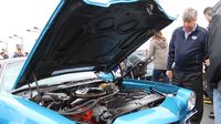 Celebrity judge Mike Joy checks under the hood of one of the Best of Show contenders Sunday at AutoFair.