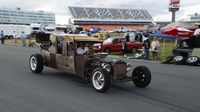 Fans circle the 1.5-mile superspeedway in a custom rat rod during opening day of the Charlotte AutoFair at Charlotte Motor Speedway.