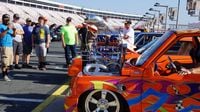 Cars look over the thousands of classics, customs and hot rods displayed along pit road during a busy Saturday at the Pennzoil AutoFair presented by Advance Auto Parts.