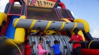 Kids climb a bounce house in the Play Zone during a busy Saturday at the Pennzoil AutoFair presented by Advance Auto Parts.