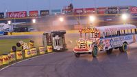 Rocky River Church's Donnie Icenhour drives past the overturned bus of Venture Church's David Henderson during Round 6 of the Bojangles' Summer Shootout at Charlotte Motor Speedway.