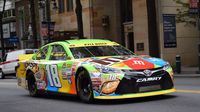 The No. 18 Toyota of Kyle Busch roars through the intersection of Trade and Tryon streets during a Laps Around Uptown event in Center City Charlotte Monday to kick off race week at Charlotte Motor Speedway.