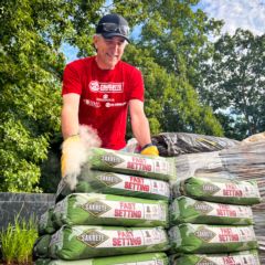 Charlotte Motor Speedway Executive Vice President and General Manager Greg Walter moves Sakrete in preparation for building a fence at Wings of Eagles during the speedway's fifth annual Day of Service.