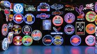 A wall of neon signs fills a vendor booth in the manufacturers' midway during opening day at the Pennzoil AutoFair at Charlotte Motor Speedway.