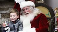 A young child poses for a photo with Santa during opening night of Charlotte Motor Speedway's seventh annual Speedway Christmas.