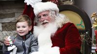 A young child poses for a photo with Santa during opening night of Charlotte Motor Speedway's seventh annual Speedway Christmas.