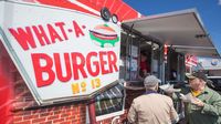Visitors take a break from watching cars to grab a bite from the Concord staple, What-a-Burger Food Truck, during Friday's action at the Pennzoil AutoFair at Charlotte Motor Speedway.